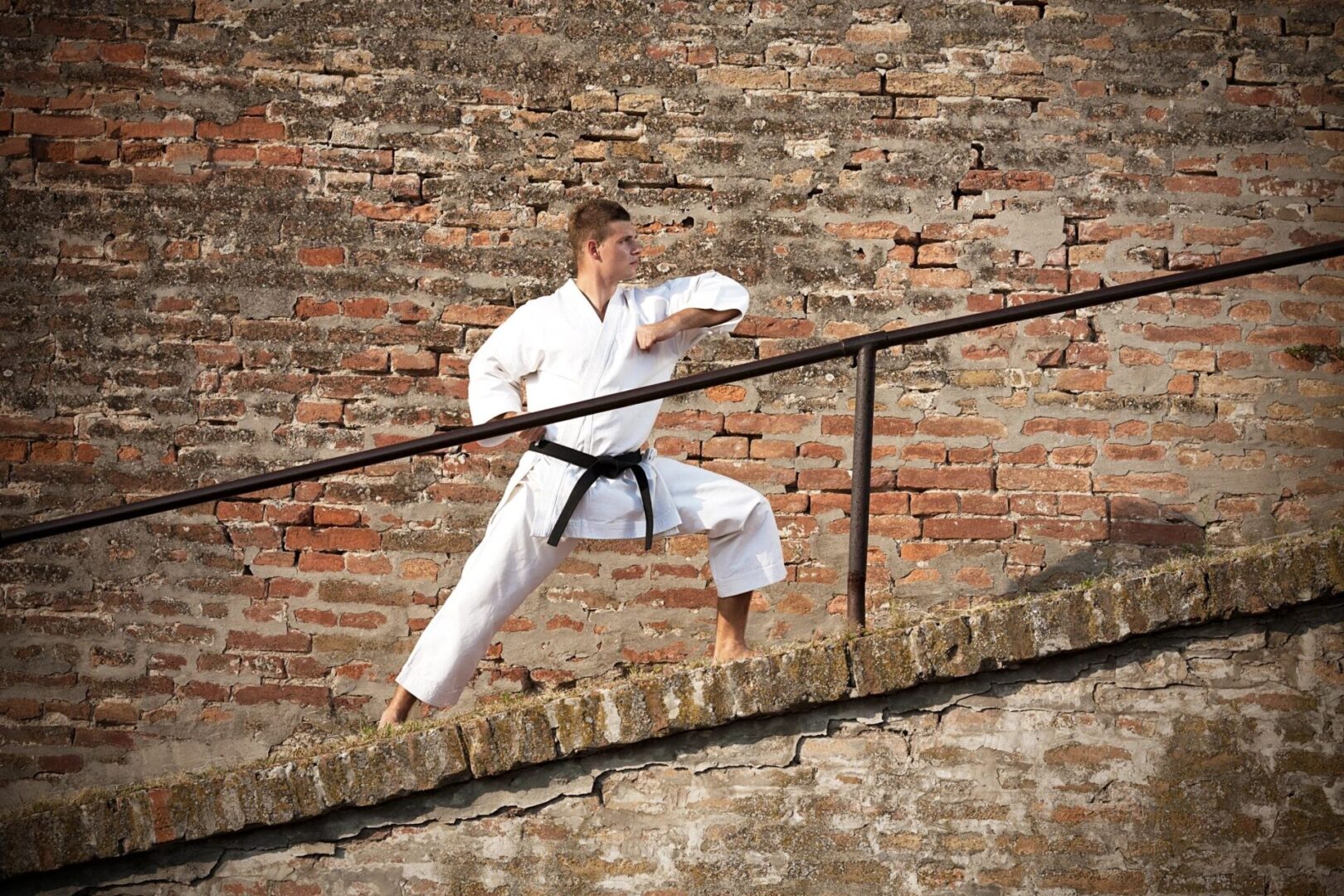 A man in white is practicing martial arts on the stairs