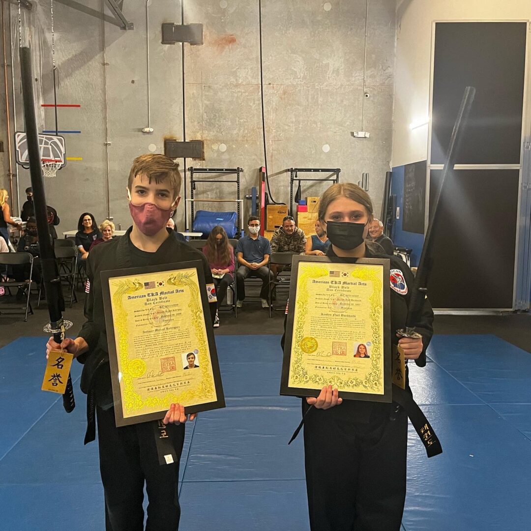 Two people holding up their awards and a gun